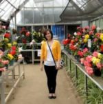 woman standing next to flowers