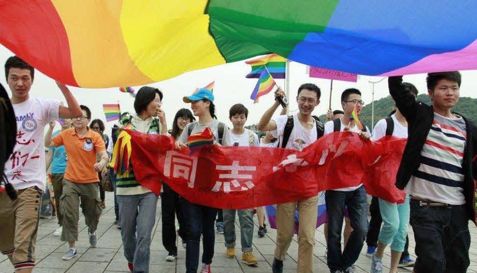 people holding a colurful flag